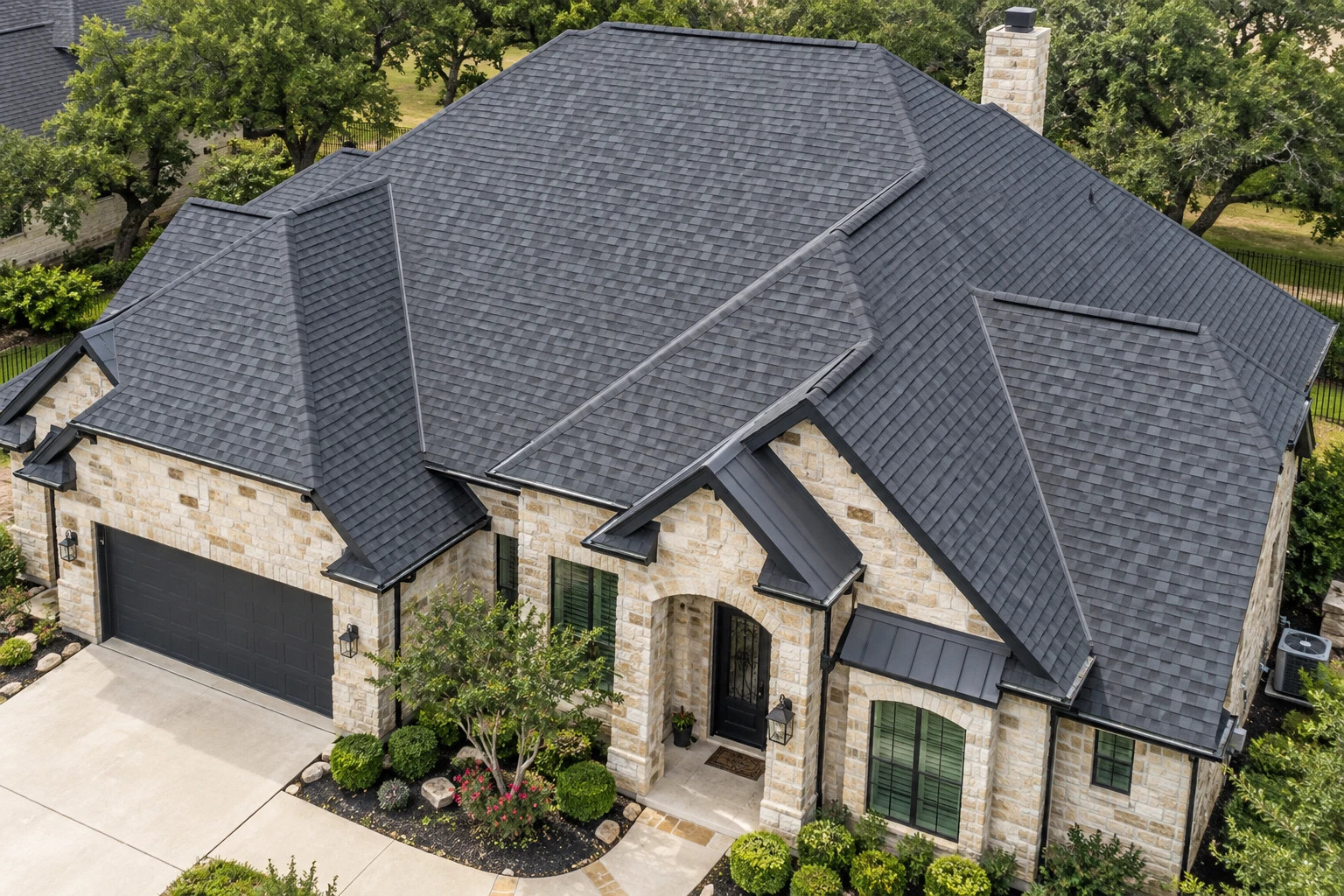 Illustrative aerial view of a stone home showing roof shingles, flashing, gutters, and exterior details