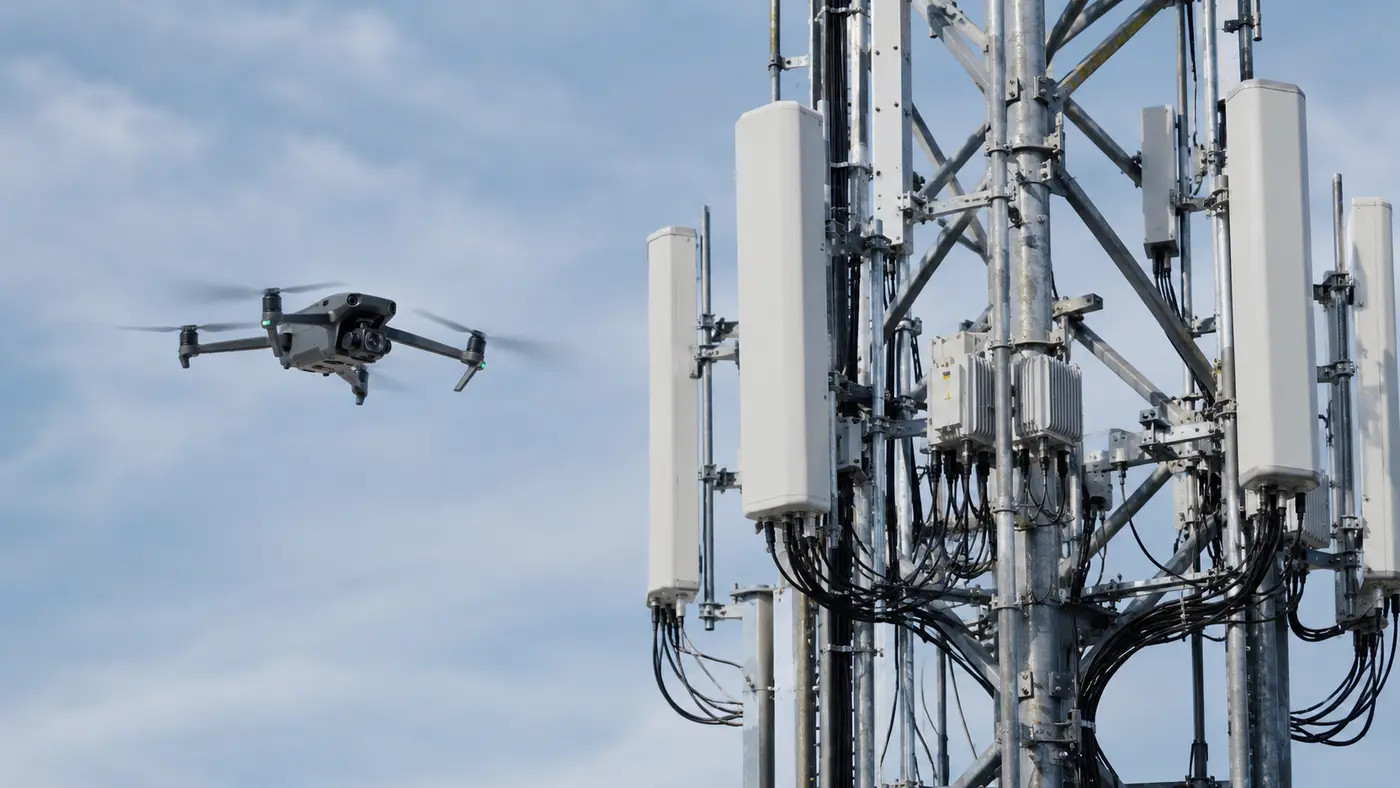 Camera drone inspecting communications tower components at close range